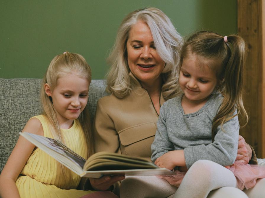 Kvinde læser højt for to piger